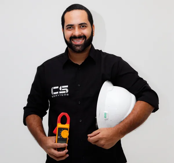 Técnico da CS Serviços com capacete e alicate amperímetro